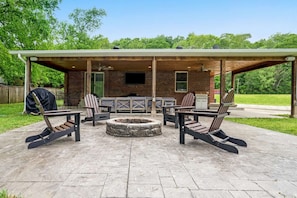 Enjoy the night on the backyard patio with a firepit and a bbq grill.