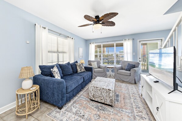 Unit B Living Room open to the kitchen and covered balcony with dining table