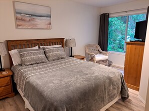 Bedroom with queen size bed and tv.
