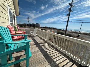 Front deck with high chairs and view of the ocean.