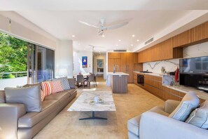 The main living area is open concept, offering a comfortable lounge and armchair to sink into while watching TV.