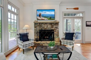 Comfy Living Room with a Flat Screen TV, Plush Couches, and a Wood-burning Fireplace