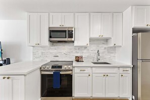 Modern kitchen with basic appliances, sleek counters, and stylish cabinetry