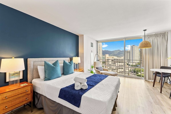 Bright studio with a queen bed, and private balcony offering city views.
