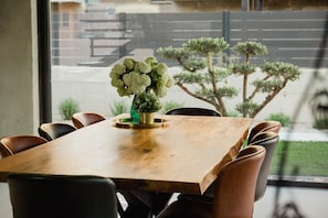 A wooden dining table set for eight people, decorated with fresh flowers in a modern villa in Baška on the island of Krk