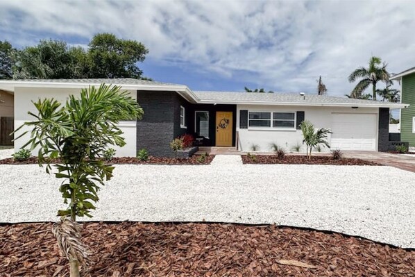 Front of house with circular drive and all new landscaping.