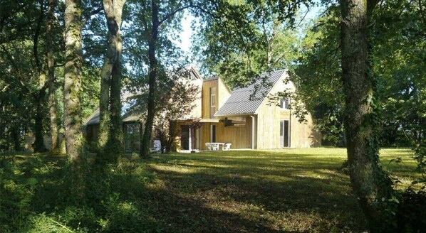 Maison contemporaine en bois située dans un vaste parc privé planté de chènes et cloturé