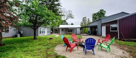 Outdoor area with corn hole boards, fire pit and children's tree swing