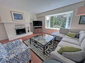 Spacious open plan living room with wood burning fireplace and countryside views