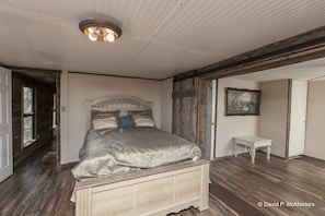 Comfy bed placed amongst the sunlight andwooden flooring.