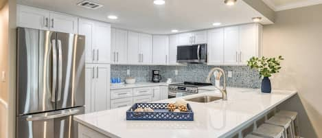 The kitchen is sparkling with brand new cabinets, countertops, and stainless appliances.