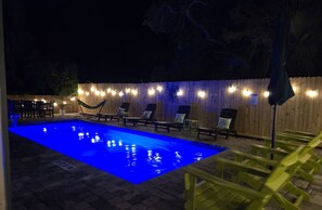 Experience the enchanting ambiance of the night with our outdoor string lighting illuminating the pool's beauty.