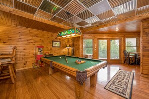 Lower level media room with sofa, TV, and pool table