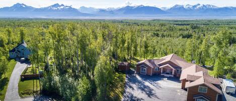 Panoramic mountains wrap the horizon. Neighboring lot is empty and wooded.