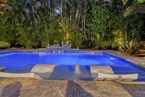 Private Heated Pool at twilight with waterfall feature.