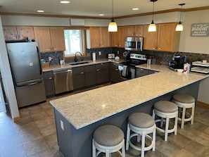 Main level kitchen, fully equipped with SS appliances, dishes, and cooking items
