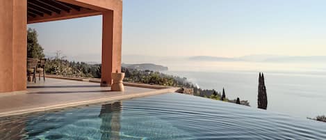 The iconic infinity heated pool reigns sublimely over the Ionian Sea. 
