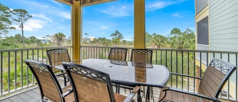 Seating area on screened in porch off living room.