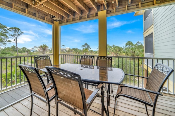 Seating area on screened in porch off living room.