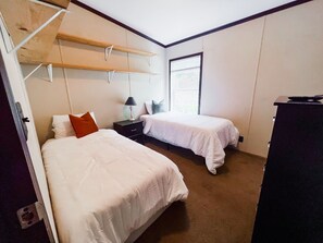 Guest room with two twin beds and a TV.