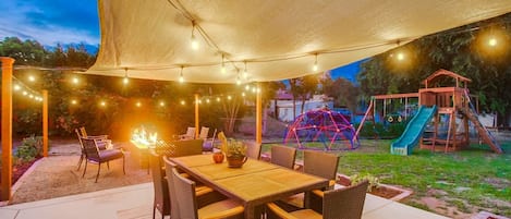Experience the magic of outdoor living, where string lights and a warm fire pit create the perfect setting for stories and laughter.