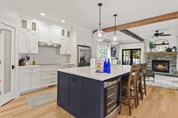 Kitchen with large island with seating for 5 and wine fridge