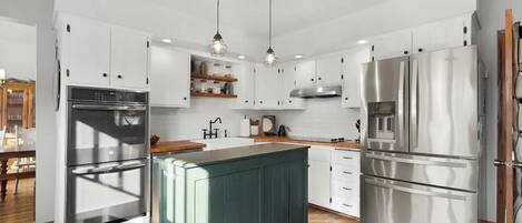 {KITCHEN} - State of the art appliances with double ovens and electric stove.