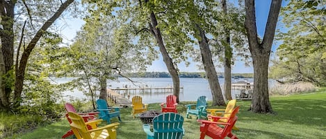 Amazing waterfront firepit with colorful Adirondack chairs!