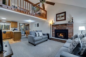 Cozy living room with a comfy couch and loveseat, perfect for relaxing after a day of adventure. Enjoy the warmth of the decorative propane fireplace and stream your favorite shows on the Smart TV for a perfect night in!  | Serhii Vacation Rentals