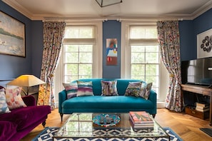 Sitting room with floor to ceiling sash windows with views over garden square 