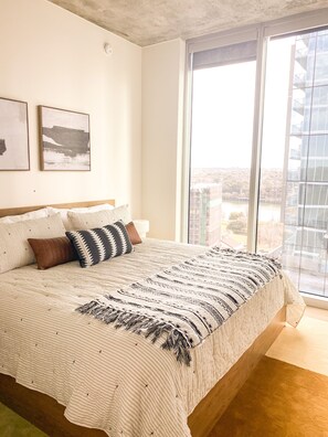 Windows and views continue into the primary bedroom with a cozy king bed.