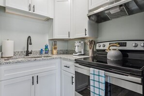 This fully stocked kitchen has a microwave, fridge, oven, baking supplies, and even food storage. 