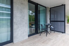 A spacious balcony with outdoor seating, perfect for relaxation. The design features modern railings and a view of the surrounding area.