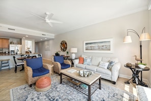 The living room offers ample, comfortable seating, a large flat screen television, door to the unit's private balcony, and breathtaking views of the Nicklaus designed golf course & Grand Lagoon.