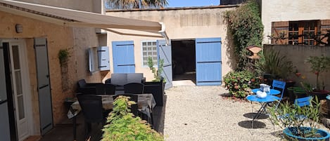 Jardin de derrière avec salon de jardin, table et barbecue