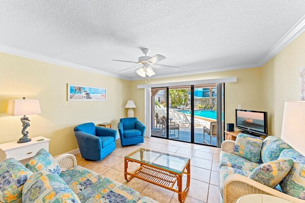 A bright and welcoming living room where soft coastal hues and natural light create the perfect space to unwind.