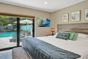 King sized bed in primary bedroom overlooking the pool