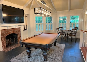 Billiards room with game cabinet and large screen TV