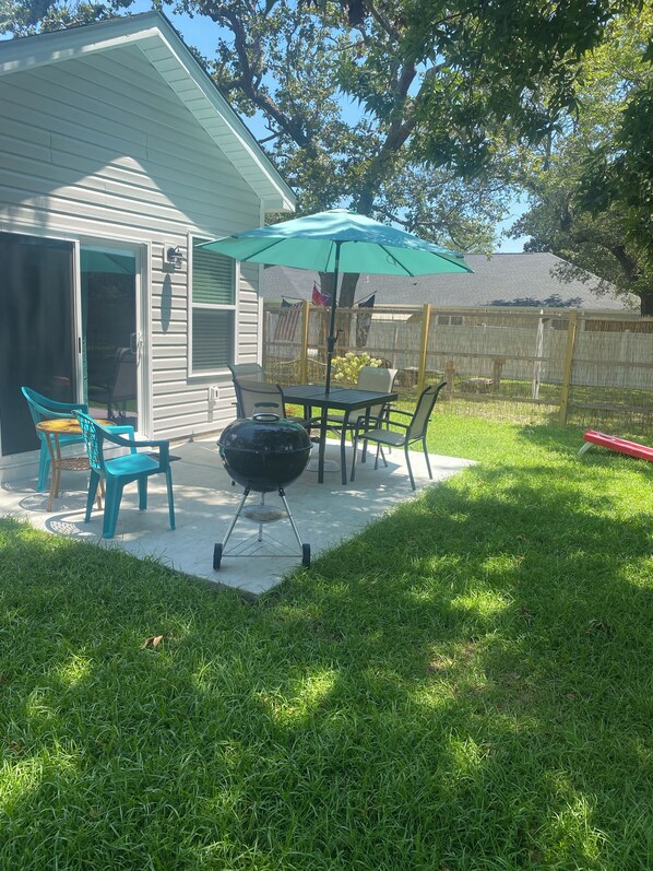 Fenced backyard with shady area to chill or grill