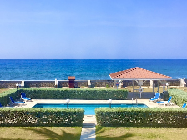 The stunning view includes the Caribbean Sea, palm trees & one of five pools.