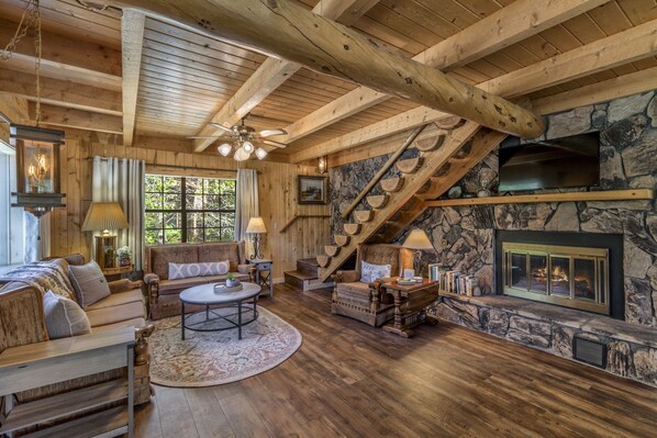 Living room with river view, 1/2 log staircase up to the third floor.