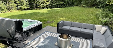 Backyard and deck with solo fire pit and hot tub.