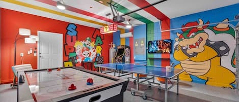 Super Mario Bros. game room with arcade, air hockey, and ping pong.