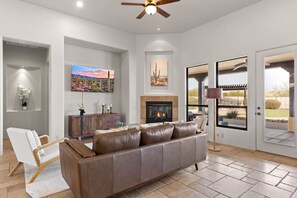 Main living room with fireplace, located next to the kitchen and dining area