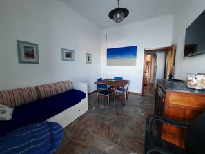 Living room with double sofa bed and window/door to the balcony with seaview.