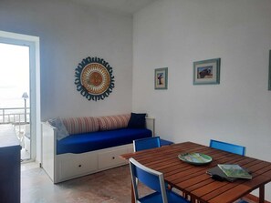 Living room with double sofa bed and window/door to the balcony with seaview.