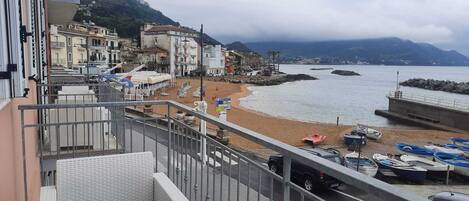 Balcony with sea view, armchairs, coffee table and awning for shade. 