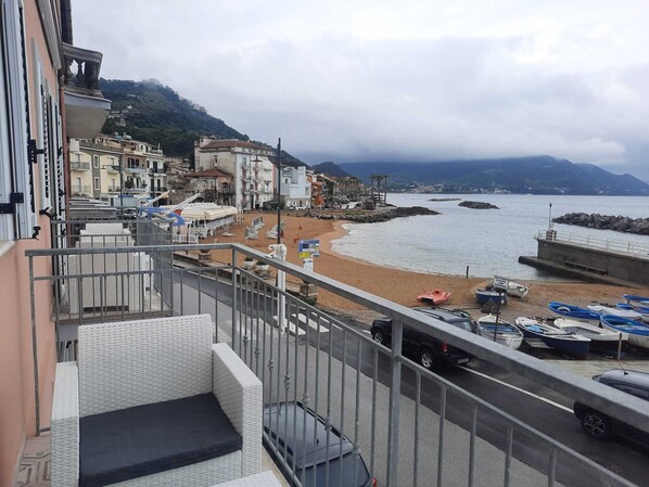 Balcony with sea view, armchairs, coffee table and awning for shade. 