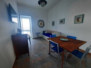 Living room with double sofa bed and window/door to the balcony with seaview.