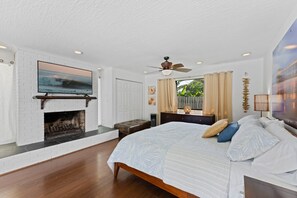 *Spacious master bedroom featuring a flat-screen TV and a cozy fireplace